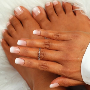 Detailed look at pink and white gradient press-on nails for hands and feet with glossy finish