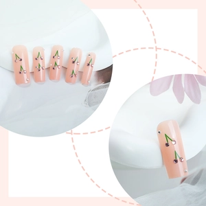 Press-on nails in nude pink gradient with hand-painted cherry rhinestone designs