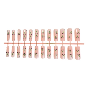 Long ballerina press-on nails in nude pink with cherry rhinestone designs on stand