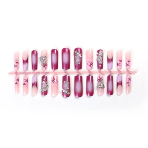 Long coffin press-on nails with pink gradient, metal stars, and pearl decorations