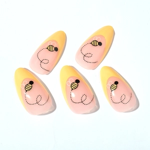 Unghie finte a mandorla French con piccoli motivi ad ape gialla e base rosa delicata