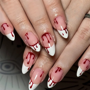 Long stiletto press-on nails with white French tips and red blood drip Halloween design