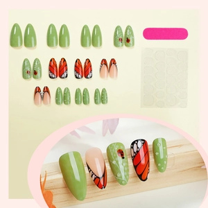 Almond-shaped press-on nails with butterfly wing patterns and 3D water drop accents
