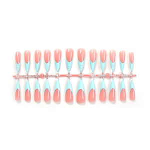 Detail of extra-long stiletto press-on nails with blue French tips and 3D textured patterns