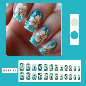 Blue press-on nails with 3D floral designs and gold glitter accents in 24 piece set