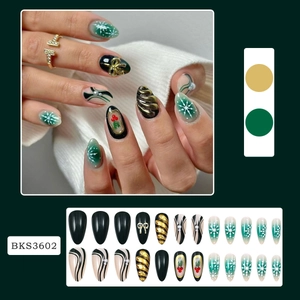 Detail of almond-shaped Christmas press-on nails with snowflakes and 3D bows