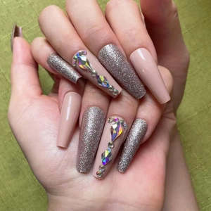 Close-up of long coffin press-on nails with silver glitter and 3D AB crystal rhinestones