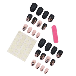 Unghie finte a mandorla nere e nude con glitter e motivi floreali dorati