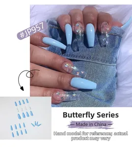 Détail de faux ongles cercueil bleu clair ornés de paillettes de papillons laser colorées