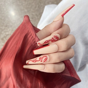 Détail de faux ongles longs cercueil avec motifs de dragon rouge et style français