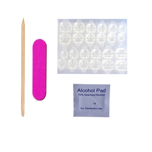 Detailed nail kit showing adhesive tabs, orange wood stick, file, and prep pad