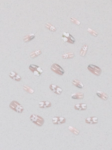 Detail of pink lavender press-on nails featuring 3D white bows and silver glitter gradient
