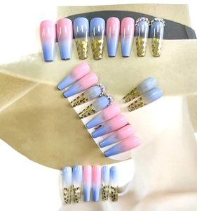 Detailed view of long coffin press-on nails with pink-blue gradient and gold foil accents
