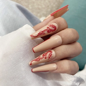 Détail de faux ongles longs ballerine avec motif dragon rouge et bords French
