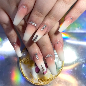 Detail of long coffin ombre press-on nails featuring white crystal rhinestone accents