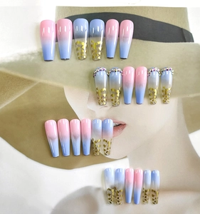 Detail of long coffin press-on nails with pink-blue gradient, gold foil, and rhinestones