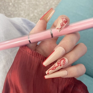Faux ongles longs forme cercueil avec motif dragon et bords french rouges élégants