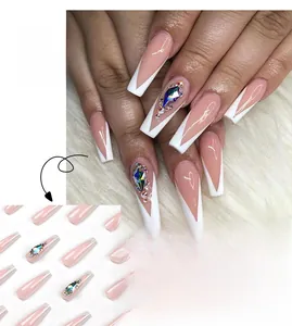 Close-up of long French coffin press-on nails with white V-tips and large rhinestone accents