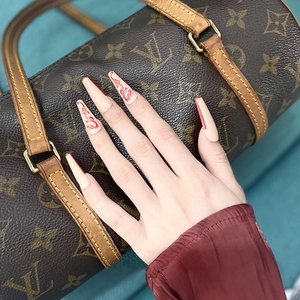 Détails macro des faux ongles cercueil avec motifs de dragon rouge et base nude