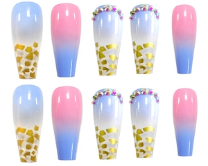 Detail of long coffin press-on nails featuring pink-blue gradient with gold foil and rhinestones