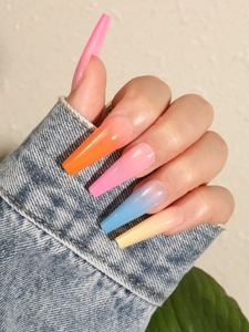 Close-up of long coffin fake nails with colorful gradient ombre finish on denim jacket