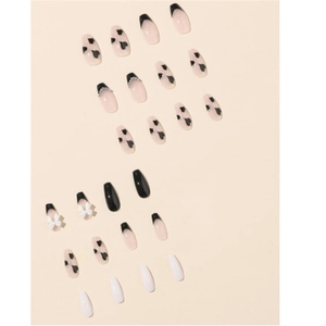 Press-on nails featuring black French tips, heart patterns, and 3D bow pearl accents