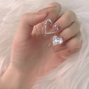 Handmade almond press-on nails in translucent pink with crystal heart rhinestones