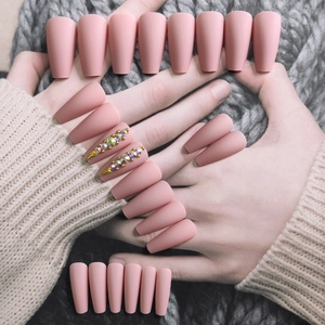 Matte nude ballerina false nails set with rhinestones and gold foil leaf accents