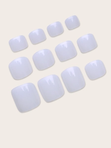 Glossy white press-on toenail tips set with 12 sizes displayed on a minimalist background