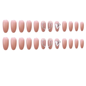 Detailed flat lay of nude pink almond nails with sparkling rhinestone heart designs