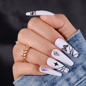 Long white coffin press-on nails with black butterfly patterns and sparkling rhinestones