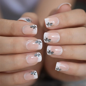 Faux ongles French ombré avec motifs floraux et accents de diamants de forme carrée