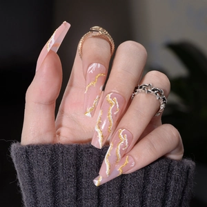 Long coffin press-on nails featuring pink marble patterns and 3D gold relief accents