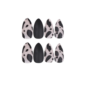 Matte black and cow print almond-shaped press-on nails in medium-long length
