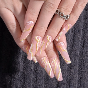 Detail of pink coffin press-on nails with gold glitter lines and white marble texture