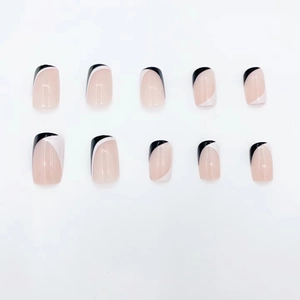 Short square press-on nails with black and white french design on pink base