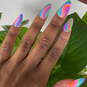 Rainbow almond press-on nails with colorful wave art patterns shown on a hand