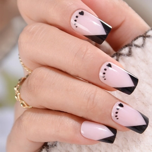 Pink French square press-on nails with black heart patterns and V-shaped tips