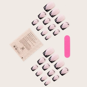 Macro view of pink and black V-shape press-on nails with heart patterns and nail file