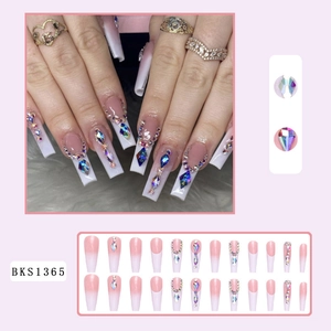 Detail of pink French gradient press-on nails with rhinestones and colorful gemstones