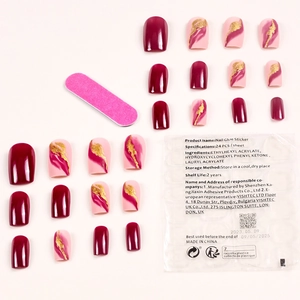 Press-on nails set in wine red and gold foil marble design with manicure tool kit