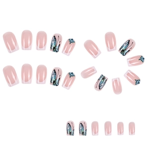 Faux ongles French nude rose avec motifs de papillons bleus et strass étincelants