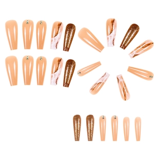 Long coffin press-on nails with marble texture, gold glitter, and small rhinestones