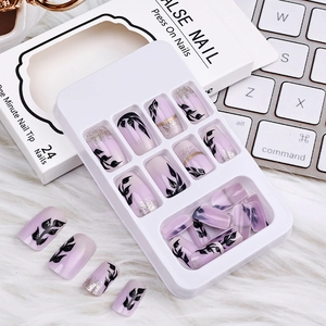 Detail of lavender gradient press-on nails with black leaf patterns and gold foil flakes