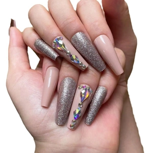 Long coffin press-on nails with silver glitter, nude pink base, and sparkly rhinestones