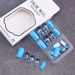 Detail of blue marble press on nails with gold foil accents and 24-piece packaging box