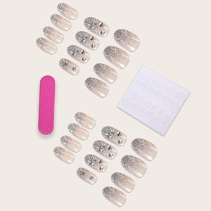 Pink press-on nails with silver glitter gradient, rhinestones, and nail file tool kit
