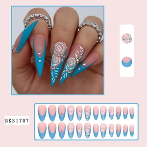Detail of blue and pink stiletto press-on nails with white rose reliefs and rhinestones