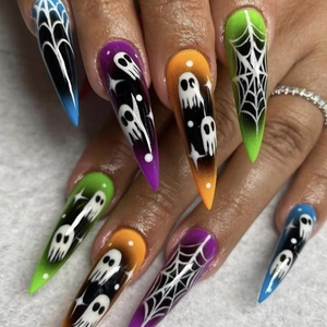 Close-up of stiletto press-on nails featuring Halloween ghosts and spider web patterns