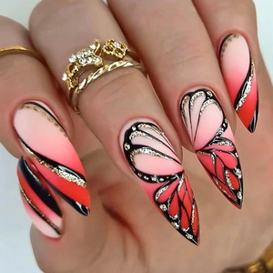 Close-up of almond stiletto nails with red pink gradient and black butterfly wing art